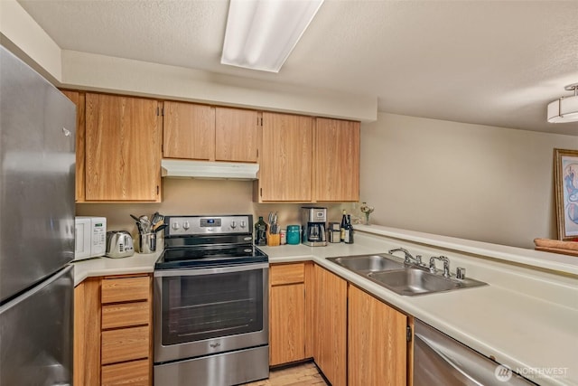 kitchen featuring appliances with stainless steel finishes, sink, and a textured ceiling