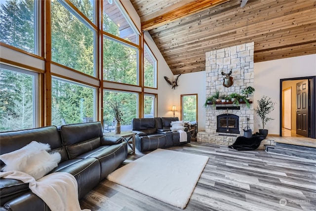 living room featuring wood ceiling, high vaulted ceiling, wood-type flooring, a stone fireplace, and beamed ceiling