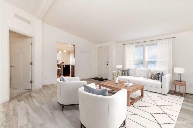 living room with vaulted ceiling and light wood-type flooring