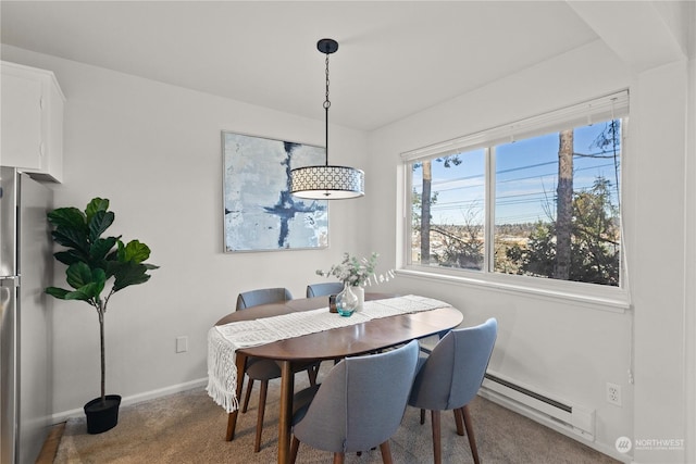 carpeted dining room with a baseboard heating unit