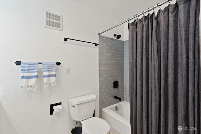 bathroom featuring shower / tub combo and toilet