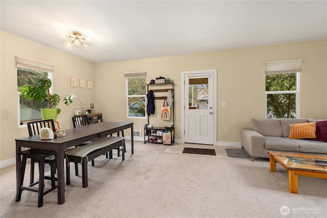 dining space featuring light carpet