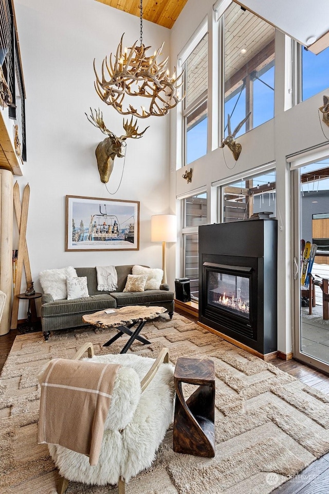 living room with a towering ceiling, wood-type flooring, and a chandelier