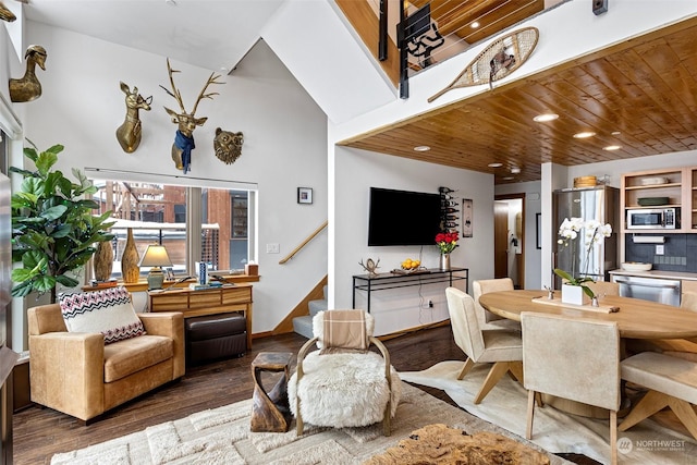 dining room with dark wood-type flooring, a high ceiling, and wooden ceiling