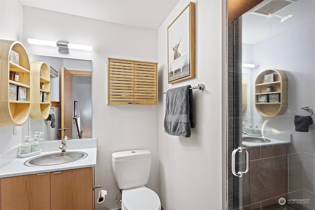 bathroom featuring walk in shower, vanity, and toilet