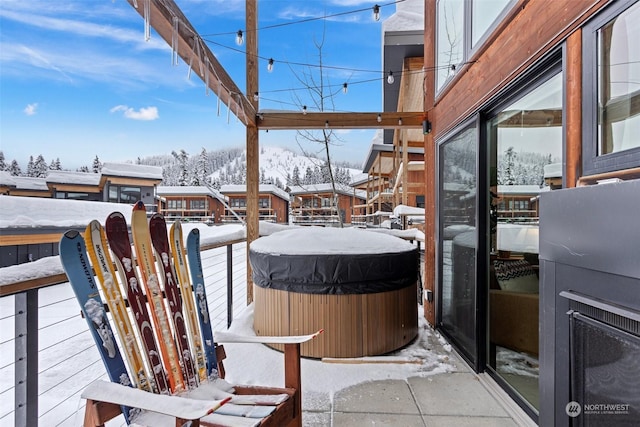 snow covered patio featuring a hot tub