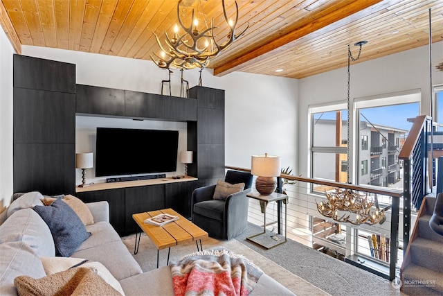 living room with beam ceiling, carpet flooring, an inviting chandelier, and wood ceiling