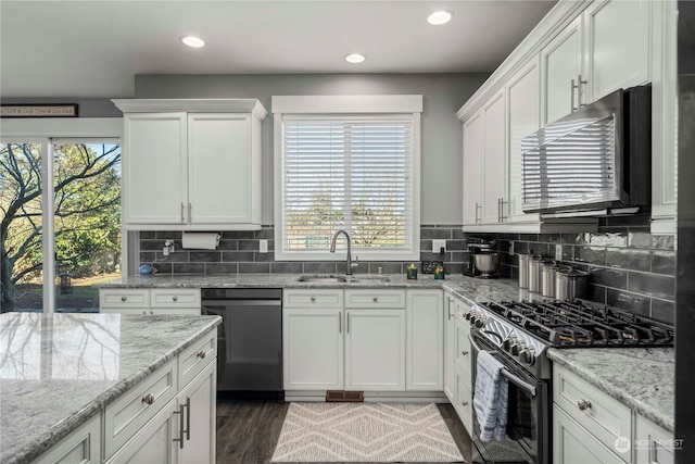 kitchen featuring white cabinetry, sink, backsplash, stainless steel appliances, and dark wood-type flooring