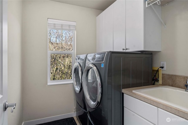 laundry area with cabinets, separate washer and dryer, and sink