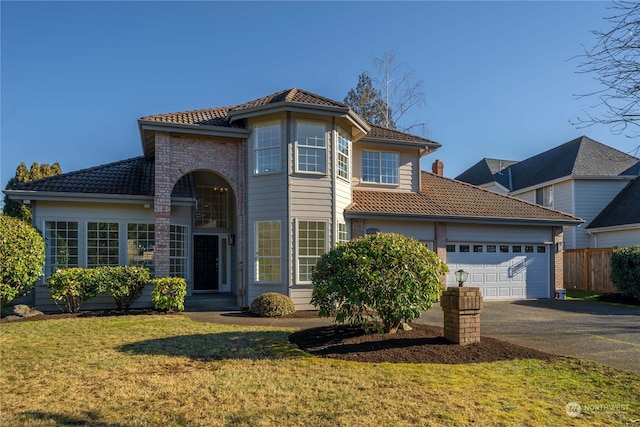 mediterranean / spanish-style house featuring a garage and a front lawn