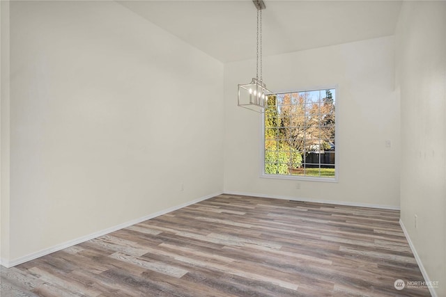 unfurnished dining area with hardwood / wood-style floors and a chandelier