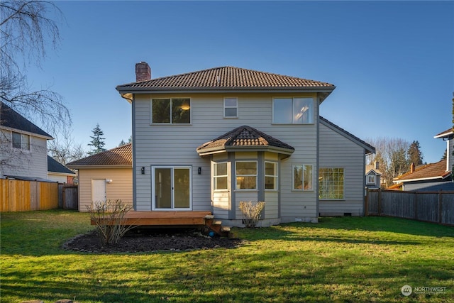 rear view of house with a wooden deck and a yard