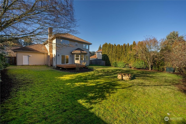 rear view of house with a deck and a lawn