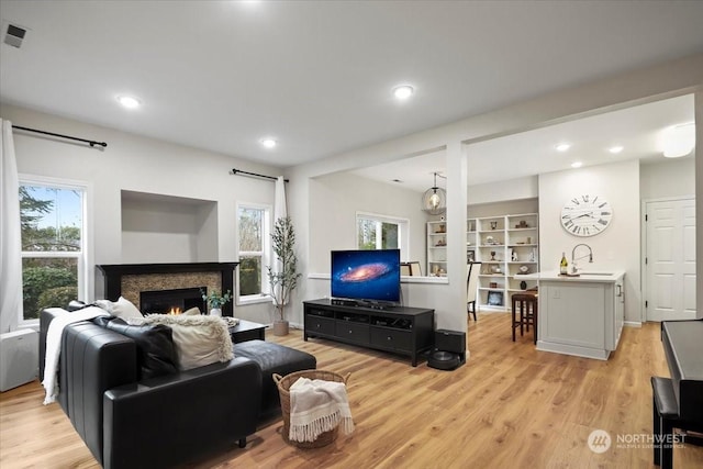 living room with sink and light hardwood / wood-style floors