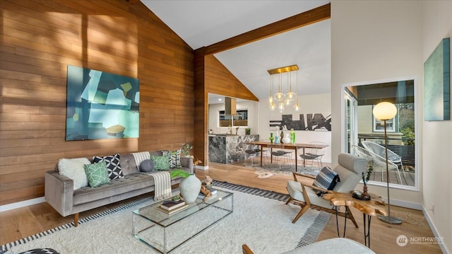 living room with an inviting chandelier, hardwood / wood-style floors, and wooden walls