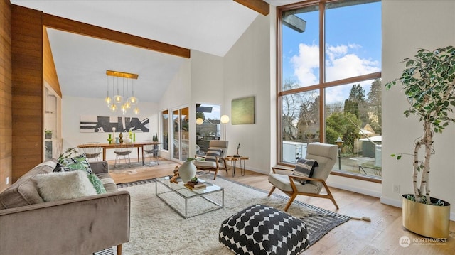 living room featuring beamed ceiling, high vaulted ceiling, an inviting chandelier, and light hardwood / wood-style flooring