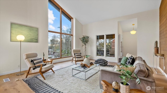 living room featuring high vaulted ceiling and light wood-type flooring