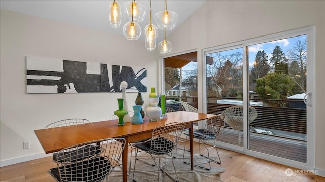 dining area with lofted ceiling and light hardwood / wood-style flooring