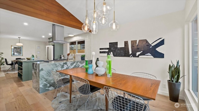 dining space with lofted ceiling and light hardwood / wood-style flooring