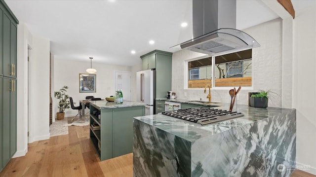 kitchen with island exhaust hood, a center island, high end white fridge, and green cabinetry