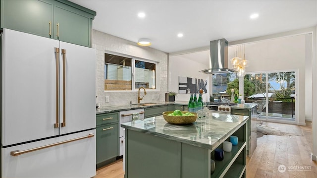 kitchen with sink, white appliances, green cabinetry, island exhaust hood, and decorative light fixtures