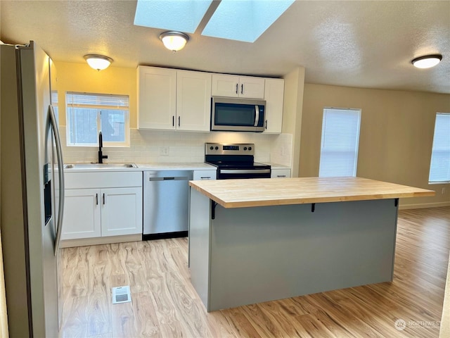 kitchen featuring butcher block counters, sink, white cabinets, and appliances with stainless steel finishes