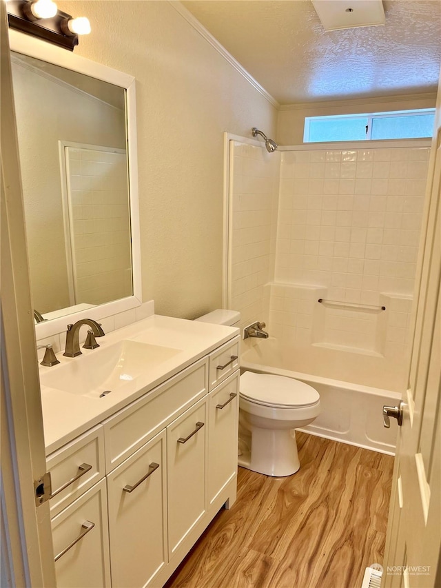 full bathroom with hardwood / wood-style floors, vanity, a textured ceiling, bathtub / shower combination, and toilet