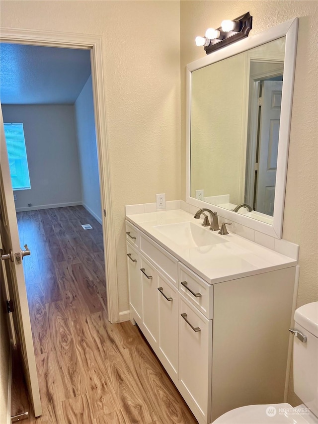 bathroom featuring hardwood / wood-style flooring, vanity, and toilet