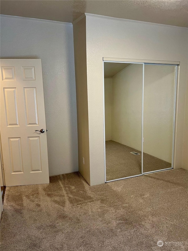 unfurnished bedroom with a closet and carpet