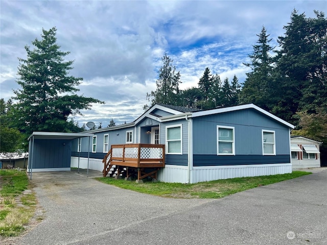 manufactured / mobile home with a wooden deck and a carport