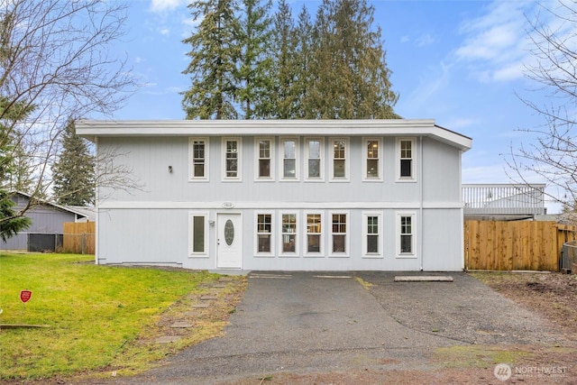 view of front facade featuring a front yard and fence