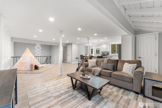 living area with vaulted ceiling with beams, light wood-style flooring, baseboards, and recessed lighting