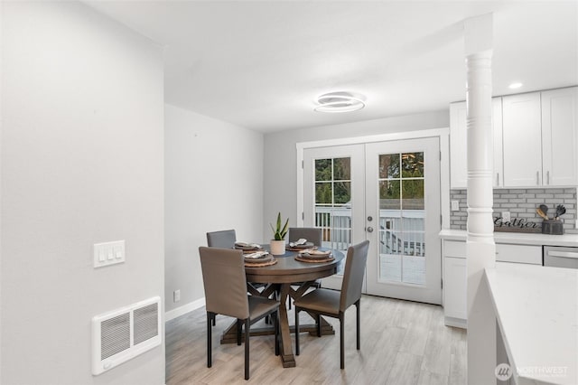 dining space with light wood-type flooring, ornate columns, baseboards, and french doors