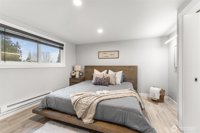 bedroom featuring recessed lighting, baseboards, baseboard heating, and wood finished floors