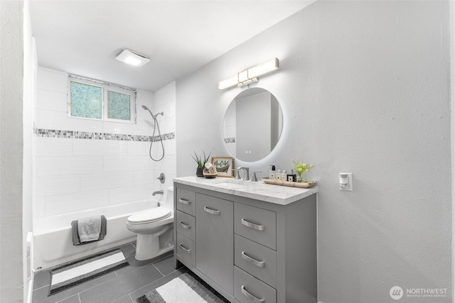 bathroom featuring washtub / shower combination, vanity, and toilet