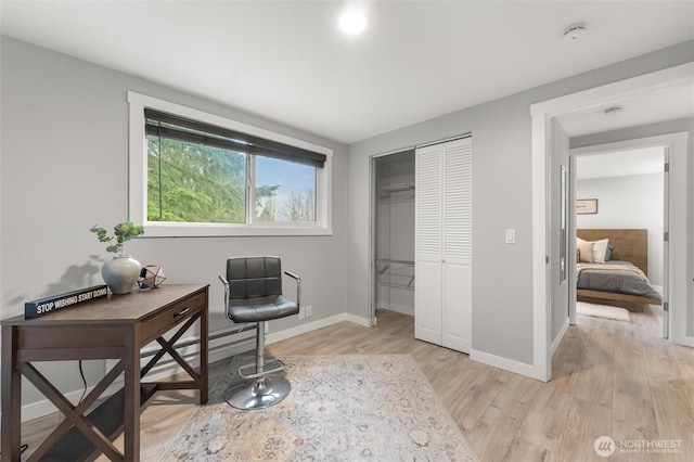 office area featuring baseboards and light wood finished floors