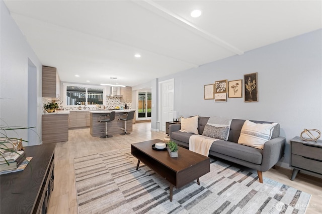 living area featuring baseboards, recessed lighting, and light wood-style floors