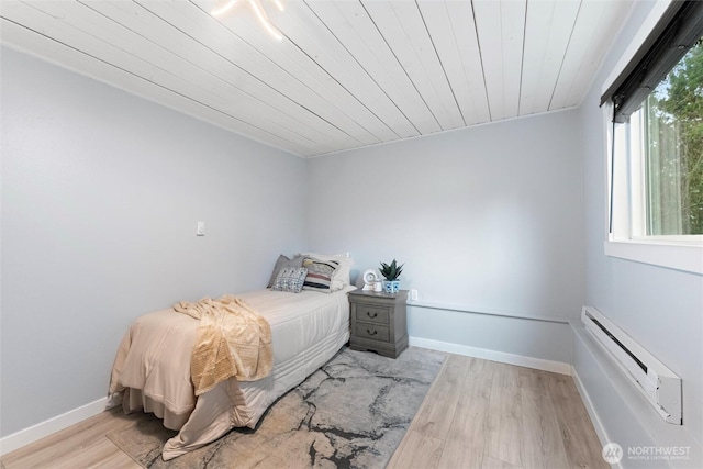 bedroom featuring wood ceiling, baseboards, light wood-style flooring, and baseboard heating