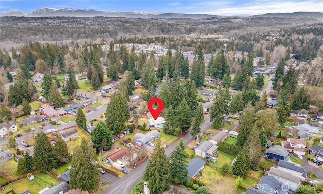 birds eye view of property featuring a forest view and a mountain view