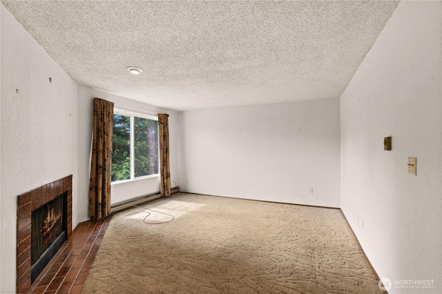 unfurnished living room featuring a baseboard heating unit, carpet, a tile fireplace, and a textured ceiling