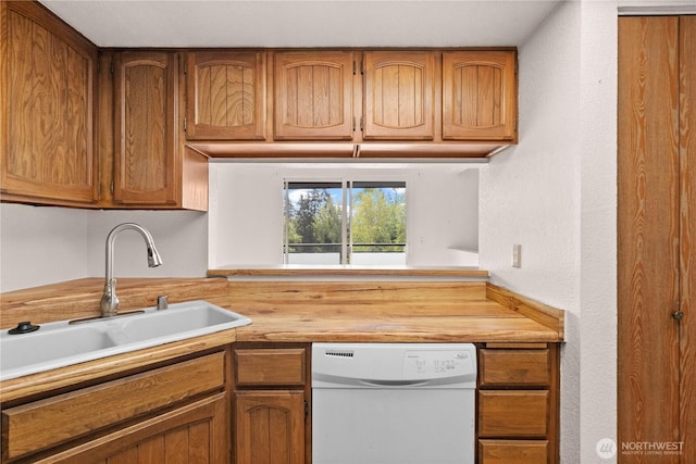 kitchen featuring butcher block counters, a sink, white dishwasher, and brown cabinetry