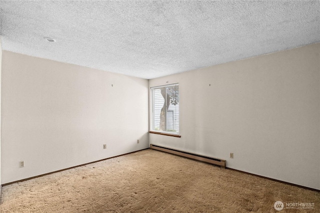 spare room featuring a textured ceiling, baseboards, carpet floors, and a baseboard radiator
