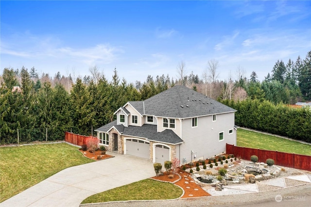 view of property featuring a garage and a front lawn