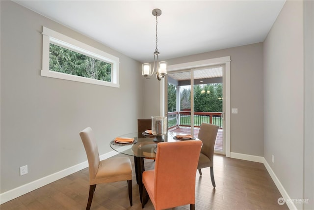 dining space with a notable chandelier, a wealth of natural light, and dark hardwood / wood-style floors