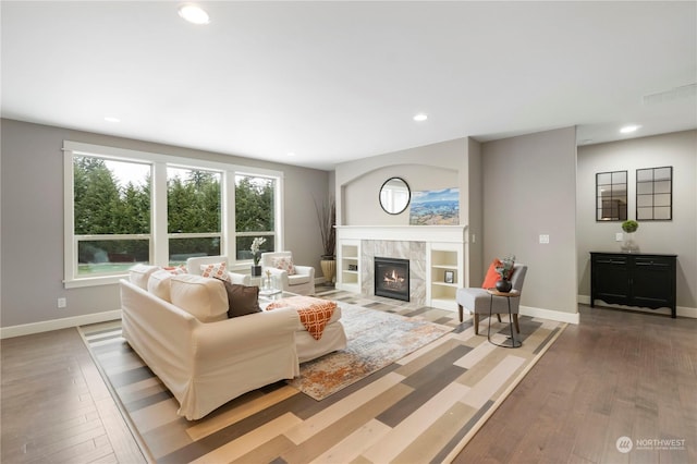 living room featuring a tile fireplace and wood-type flooring