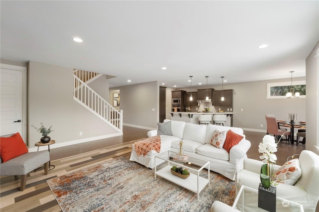 living room with an inviting chandelier and light hardwood / wood-style floors