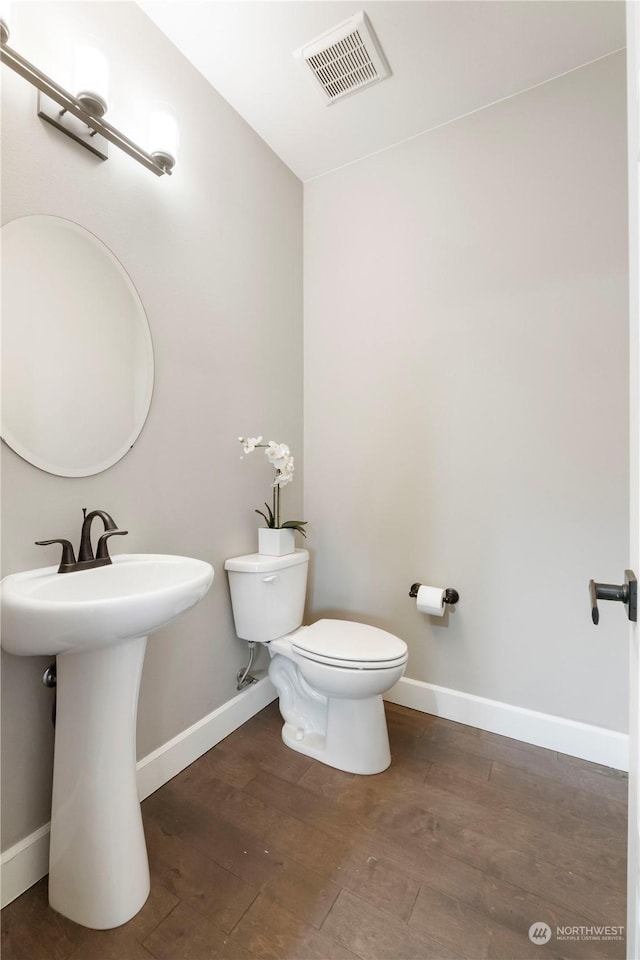 bathroom with toilet and hardwood / wood-style floors