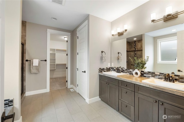 bathroom featuring vanity, backsplash, and walk in shower