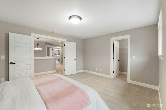 carpeted bedroom featuring a spacious closet and a closet