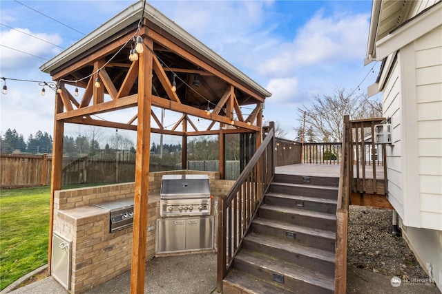 view of patio with a gazebo, an outdoor kitchen, area for grilling, and a wooden deck